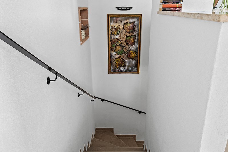 Prekrasno uređen interijer s umjetničkim detaljima i lijepim drvenim stepenicama.