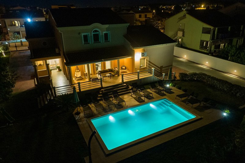 Prekrasan pogled na noćni bazen i osvijetljenu fasadu vile.