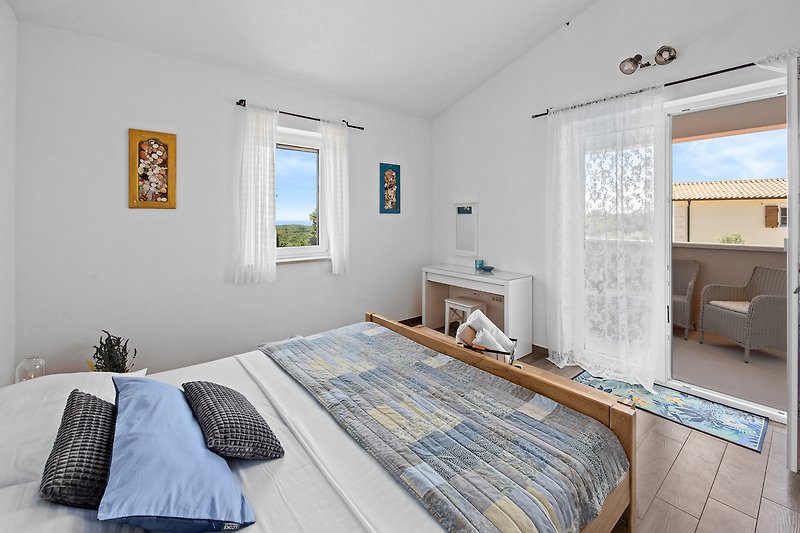 Udobna spavaća soba s drvenim namještajem i prozorom.