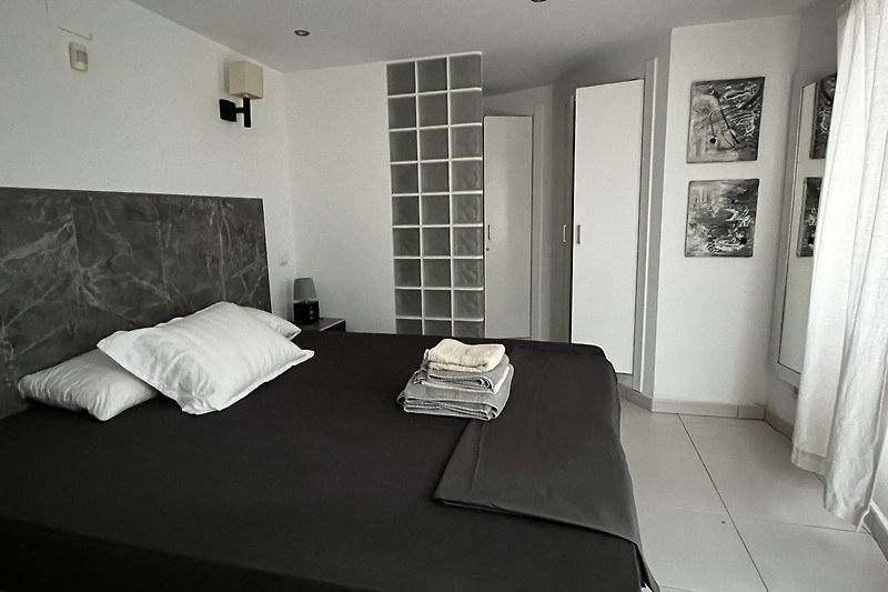 Comfortabele slaapkamer met houten meubels en donkere tinten.