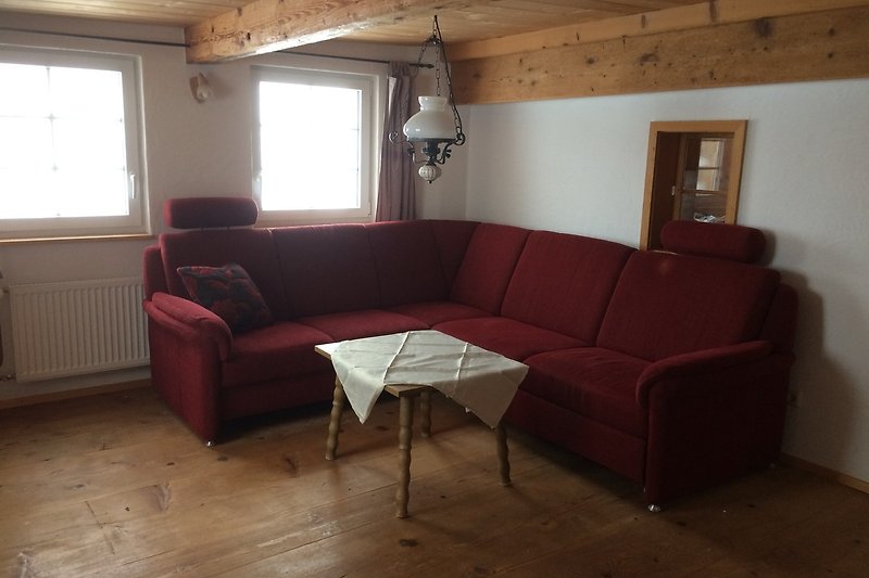 Gemütliches Wohnzimmer mit bequemer Couch und Holzboden.