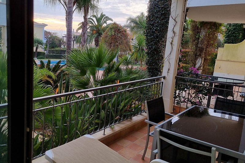 Sicht auf eine Terrasse und dem Resortschwimmbad von der Wohnungssuite