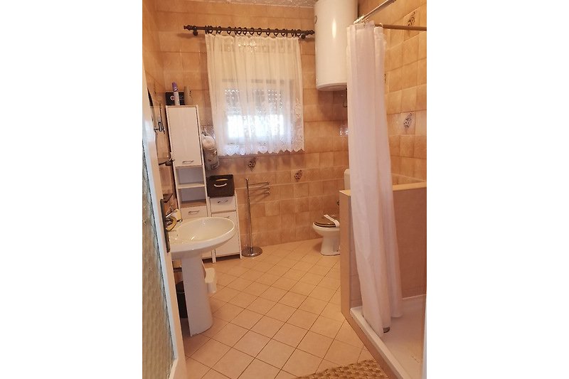 Elegant bathroom with purple shower curtain and wood flooring.