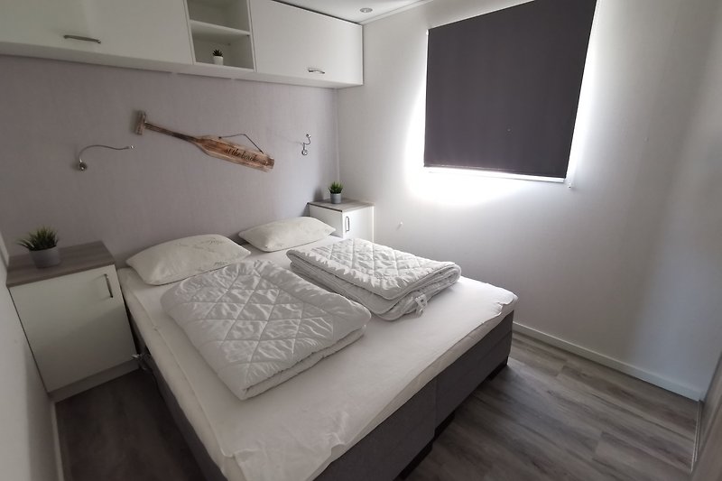 Modernes Schlafzimmer mit stilvoller Einrichtung und Holzbett.