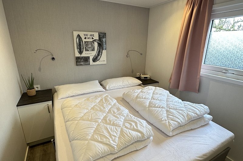Schlafzimmer mit gemütlichem Bett, elegantem Lampenschirm und Fenster.