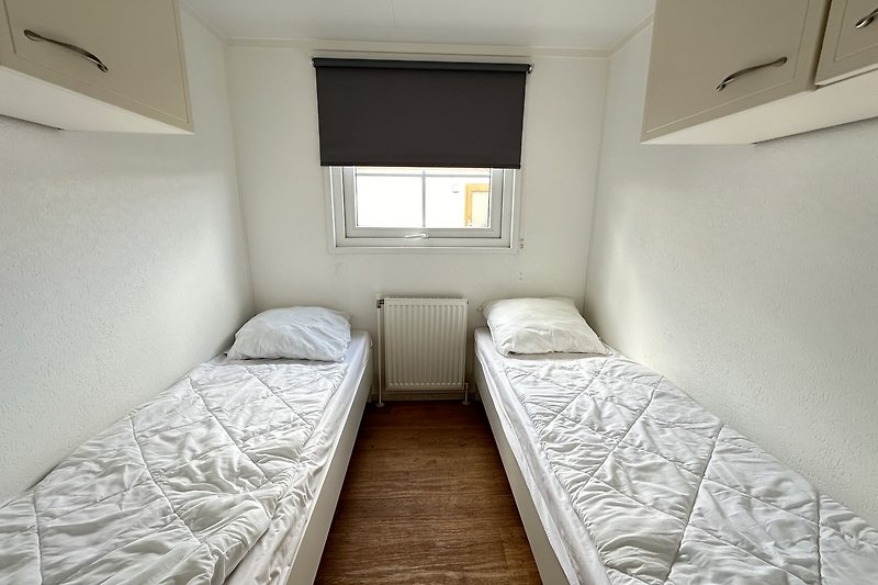 Stilvolles Schlafzimmer mit symmetrischem Design und gemütlichem Bett.
