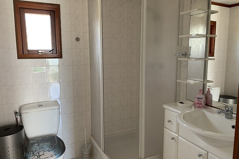 Schönes Badezimmer mit Holzmöbeln, Spiegel und Fliesen.