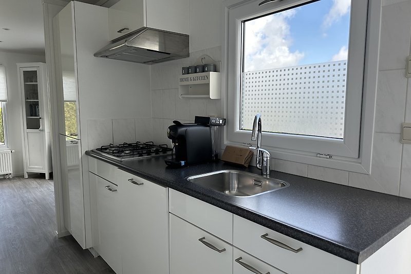 Moderne Küche mit Holzmöbeln, Granit-Arbeitsplatte und Edelstahl-Spüle.