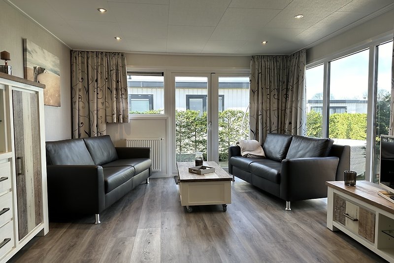 Stilvolles Wohnzimmer mit bequemer Couch, Pflanze, Lampe und Fenster.