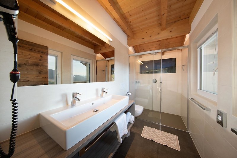 Helles Badezimmer mit Glasdusche, Regenbrause und Doppelwaschbecken