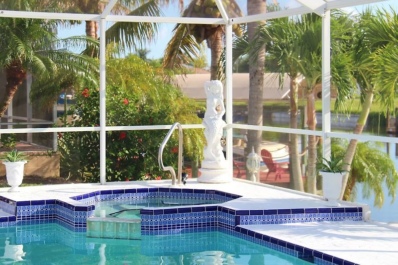 Schwimmbecken mit Sonnenliegen und Blick auf das azurblaue Wasser. Perfekt für Entspannung und Freizeit.