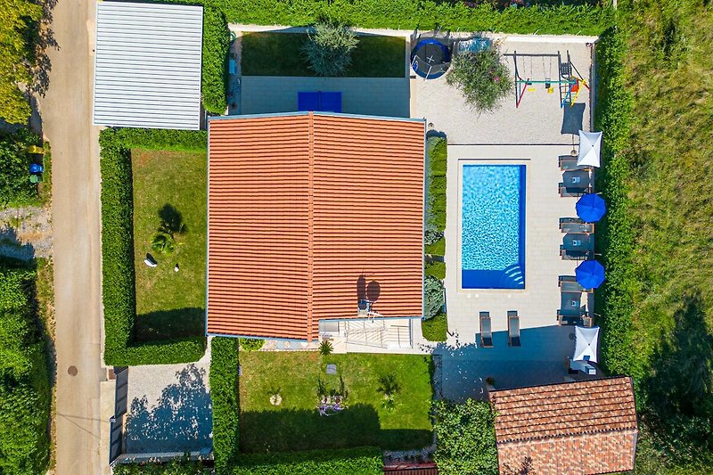 Moderne Ferienwohnung mit grünem Garten, blauem Himmel und stilvollem Design.