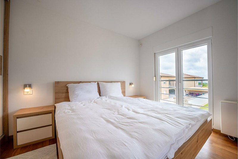 Verbringen Sie Ihren Urlaub in diesem stilvollen Schlafzimmer mit hochwertigem Mobiliar und gemütlichem Bett.