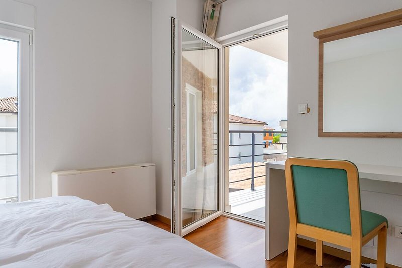 Verbringen Sie Ihren Urlaub in diesem komfortablen Schlafzimmer mit stilvollem Holzmobiliar und gemütlichem Bett.
