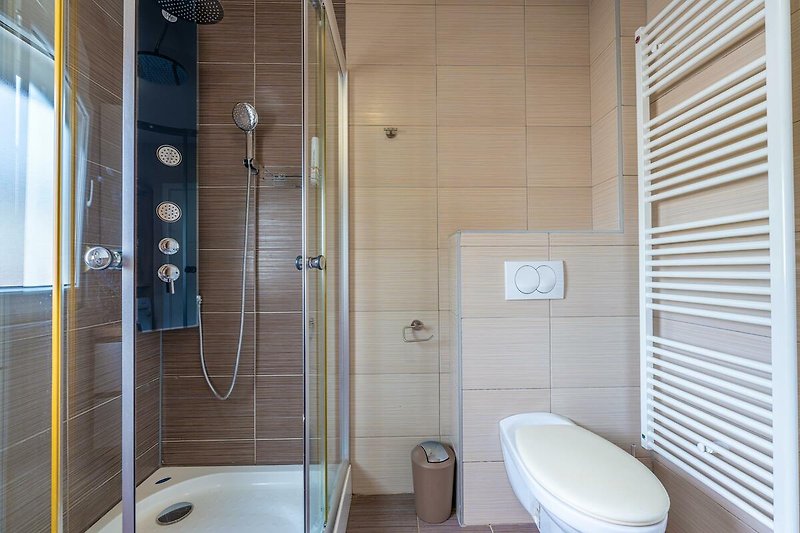 Willkommen in diesem stilvollen Badezimmer mit lila Akzenten. Entspannen Sie in der Badewanne oder unter der Dusche.