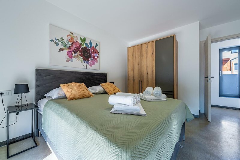 Gemütliches Schlafzimmer mit stilvoller Einrichtung und blauem Bettzeug.