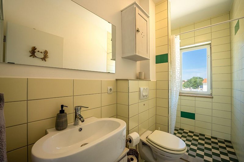 Schönes Badezimmer mit lila Waschbecken und stilvoller Beleuchtung.