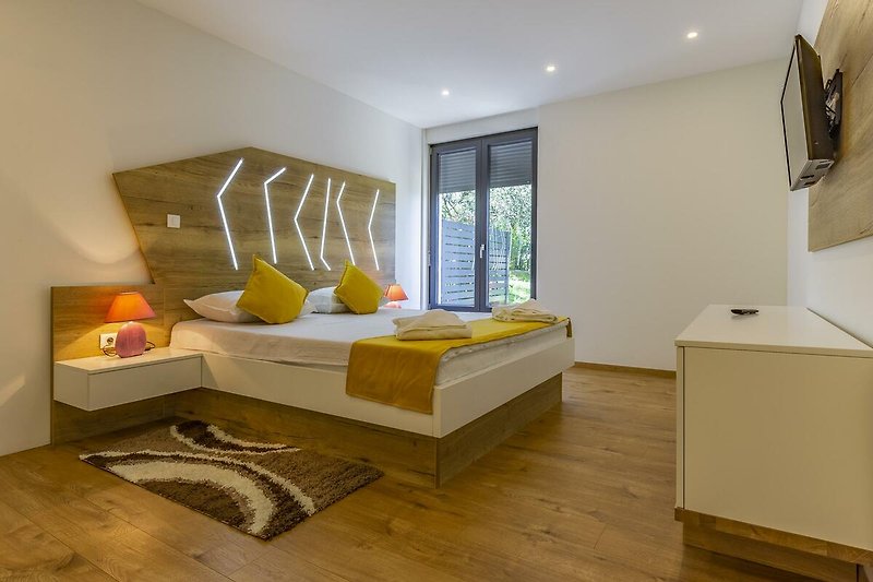 Gemütliche Wohnung mit Holzboden, modernem Interieur und bequemem Bett.