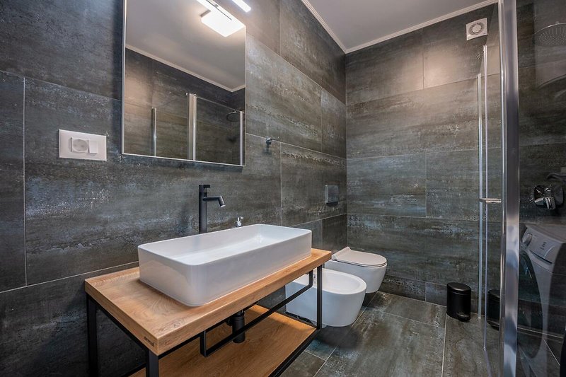 Schönes Badezimmer mit stilvollem Spiegel und modernem Waschbecken.