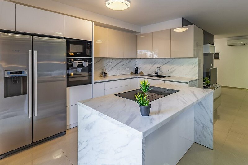 Moderne Küche mit stilvollem Design, hochwertigen Geräten und schönen Holzböden.
