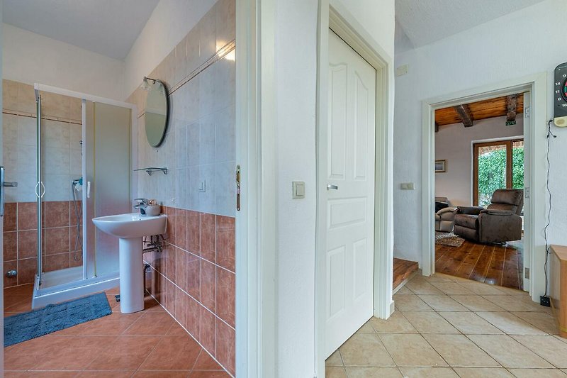 Schönes Badezimmer mit Holzboden und modernen Armaturen.