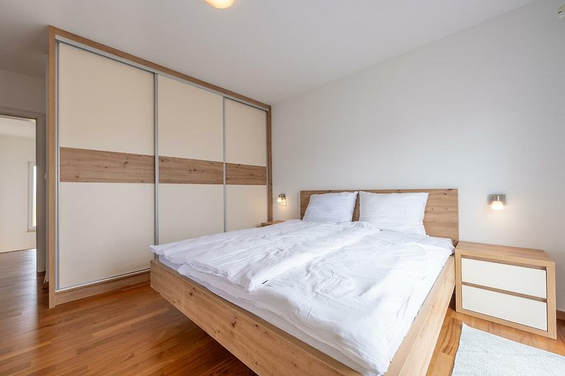 Entspannen Sie in diesem komfortablen Schlafzimmer mit stilvollem Holzmobiliar und gemütlichem Bett.