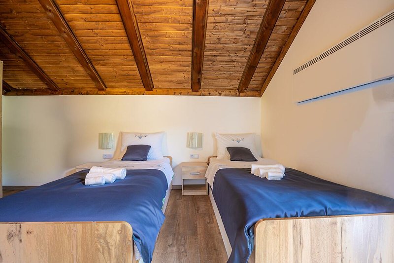 Gemütliches Schlafzimmer mit bequemem Bett und stilvollem Holzboden. Perfekt zum Entspannen und Träumen.