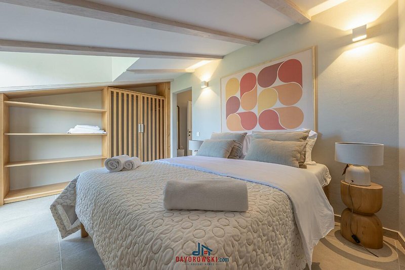Stilvolles Schlafzimmer mit bequemem Bett und dekorativer Beleuchtung.