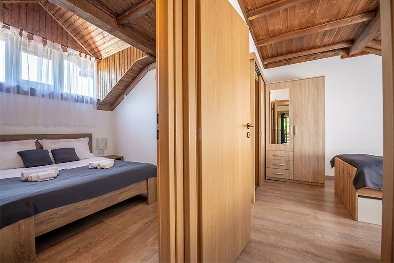 Gemütliches Schlafzimmer mit stilvollem Holzbett und bequemer Beleuchtung. Perfekt zum Entspannen und Träumen.