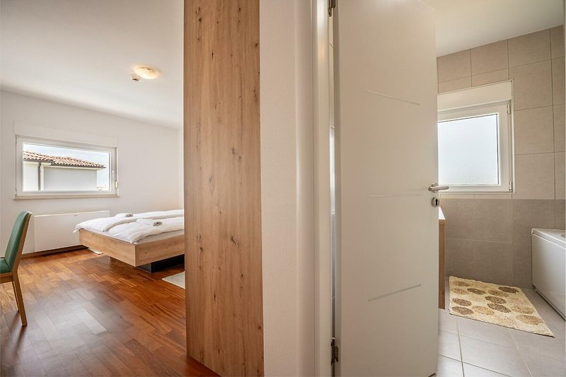 Willkommen in diesem stilvollen Apartment mit hochwertigem Interieur und gemütlichem Bett. Entspannen Sie und genießen Sie die schöne Aussicht.