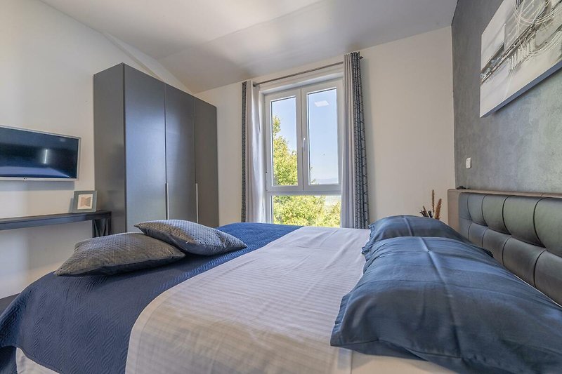 Einladendes Schlafzimmer mit bequemem Bett und stilvollem Holzmobiliar.