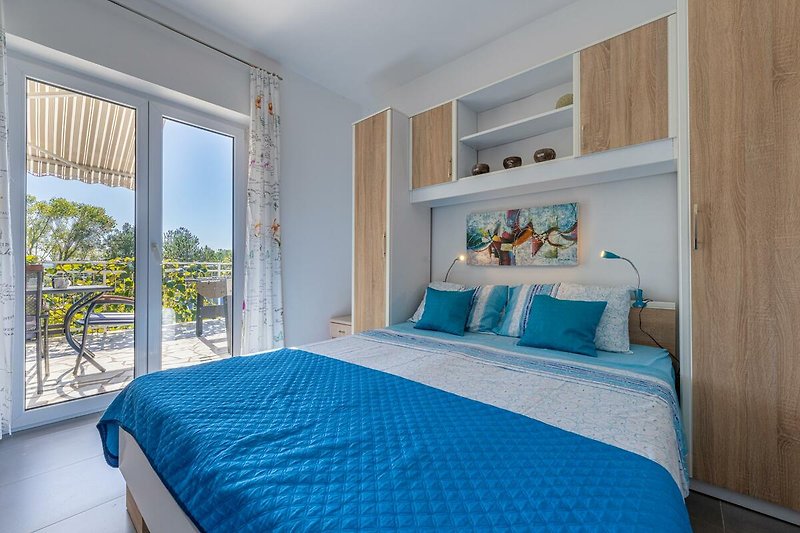 Gemütliches Schlafzimmer mit blauer Inneneinrichtung und Holzmöbeln.