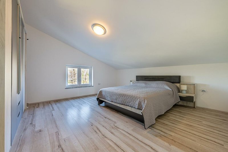 Gemütliches Schlafzimmer mit Holzboden und bequemem Bett.