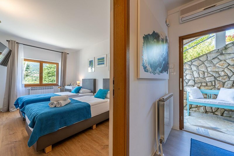 Gemütliches Schlafzimmer mit blauem Bett und stilvoller Einrichtung.