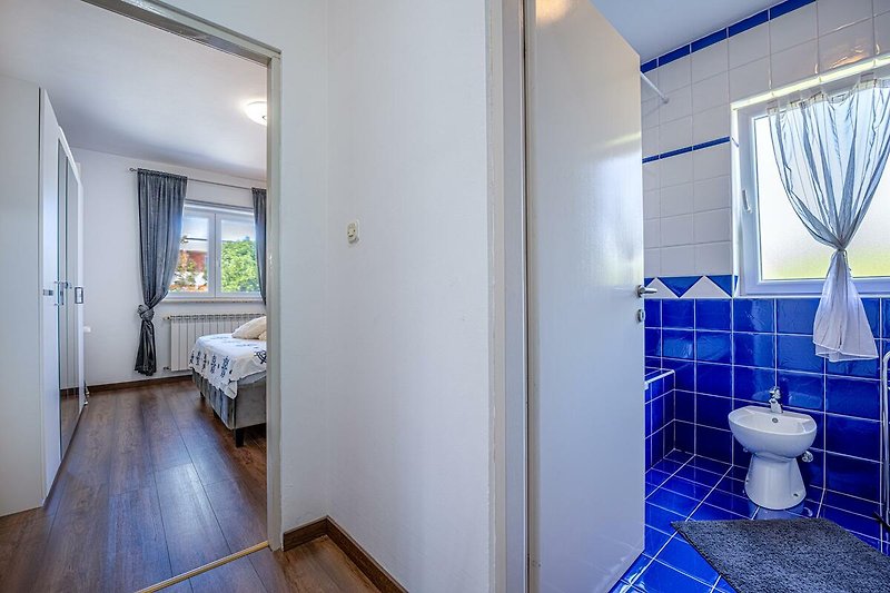 Gemütliches Badezimmer mit Holzfußboden, Fenster und stilvoller Inneneinrichtung.