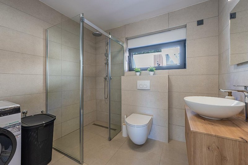 Modernes Badezimmer mit lila Akzenten, Spiegel, Toilette und Dusche.
