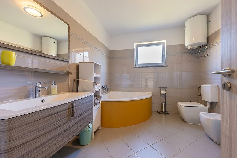 Gemütliches Badezimmer mit modernen Armaturen und Holzmöbeln.