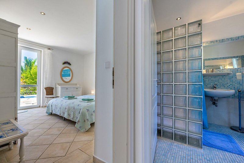 Gemütliches Schlafzimmer mit stilvollem Holzmobiliar und blauem Himmel.