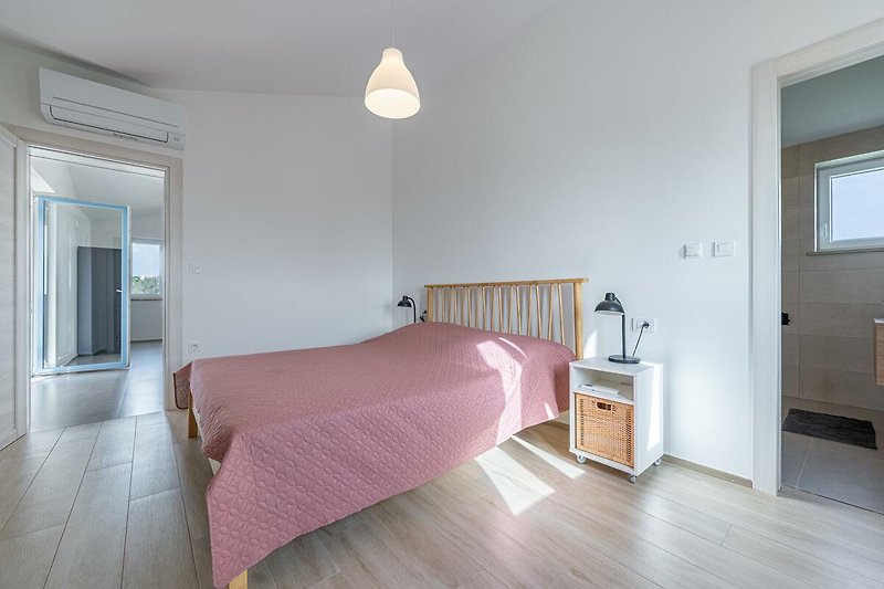 Modernes Schlafzimmer mit elegantem Holzbett und stilvoller Beleuchtung.