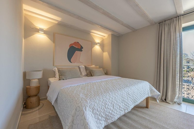 Elegantes Schlafzimmer mit gemütlichem Bett und stilvoller Beleuchtung.