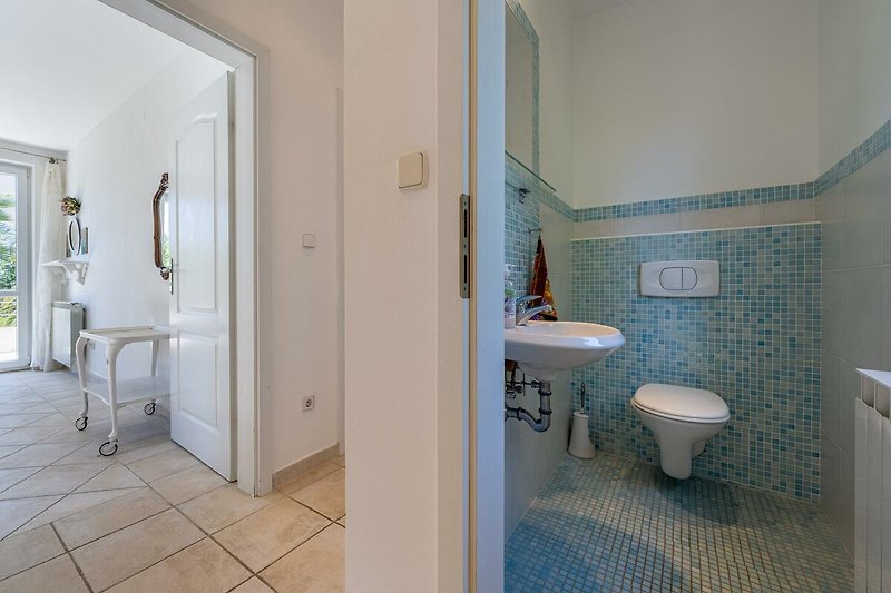 Schönes Badezimmer mit Spiegel, Waschbecken und Fliesen.