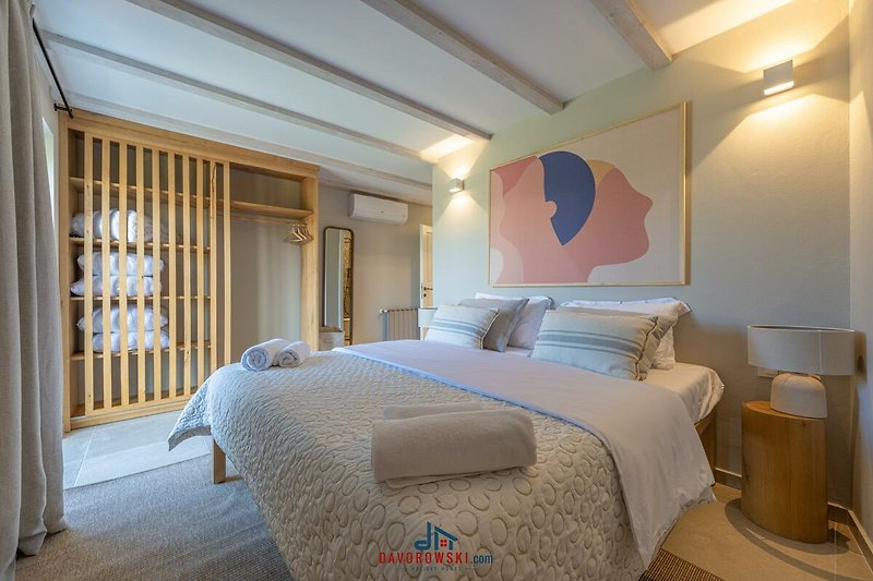 Stilvolles Schlafzimmer mit bequemem Bett und dekorativer Beleuchtung.