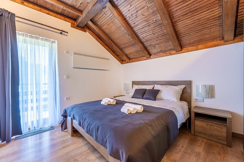 Gemütliches Schlafzimmer mit Holzbett und gemütlicher Beleuchtung. Entspannen Sie sich und genießen Sie den Komfort.