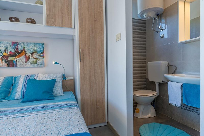 Gemütliches Badezimmer mit blauer Inneneinrichtung und komfortabler Ausstattung.