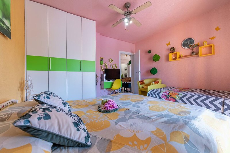 Gemütliches Schlafzimmer mit lila Bett und stilvoller Dekoration.