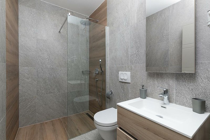 Schönes Badezimmer mit Spiegel, Wasserhahn und stilvollem Design.