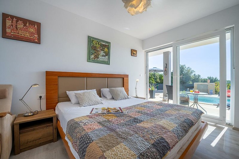Stilvolles Schlafzimmer mit gemütlichem Bett und Holzboden.