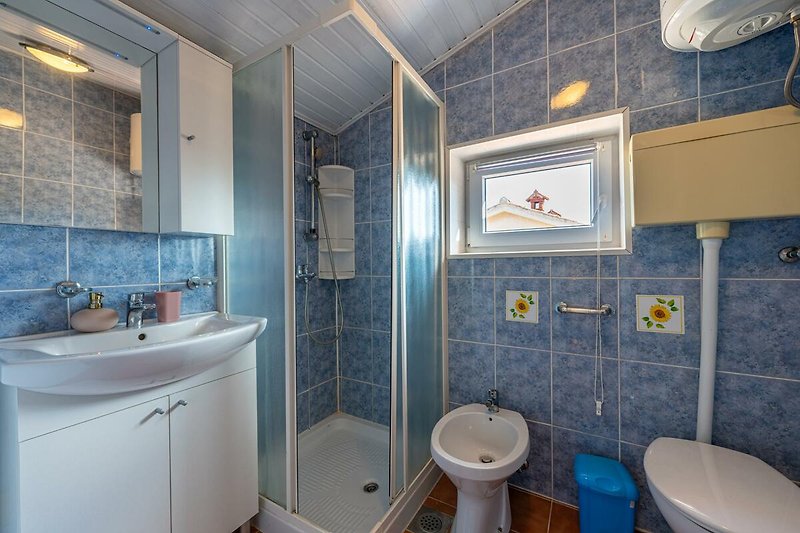 Schönes Badezimmer mit lila Spiegel und Armatur.