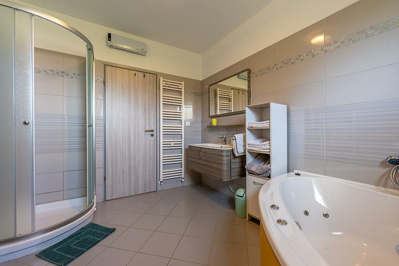 Gemütliches Badezimmer mit stilvoller Einrichtung und luxuriöser Badewanne.