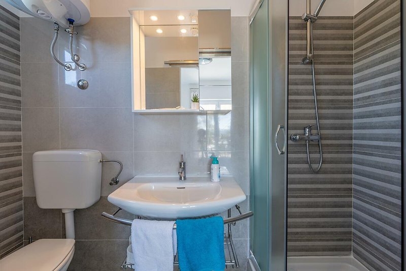 Ein modernes Badezimmer mit lila Waschbecken und stilvoller Einrichtung.